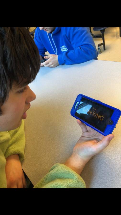 A student watches the new Lion King trailer on his phone.