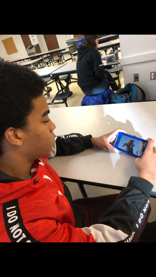 Nefari Hassan, a senior at Hall, watches the trailer for the new Lion King during his free period in the cafeteria.