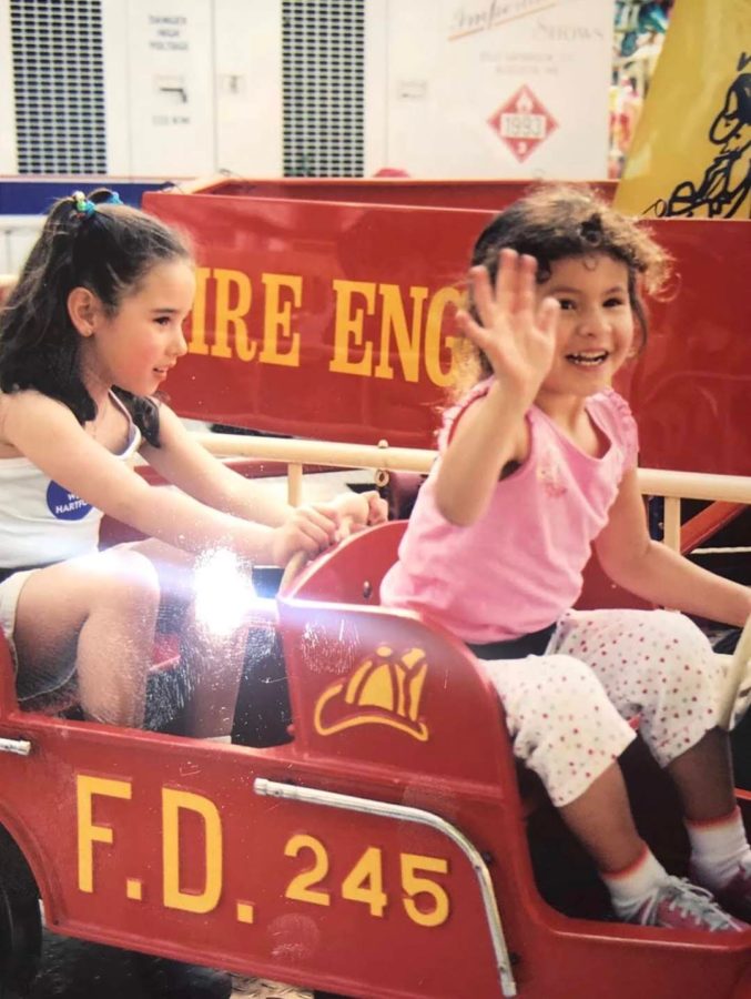 Mariana and Sarah on a toy fire truck.