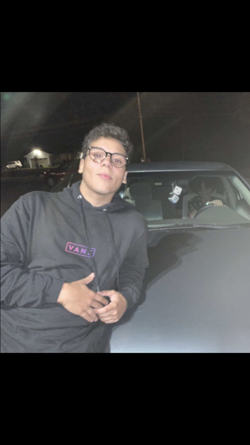 This image shows Sam Bastos leaning on a car