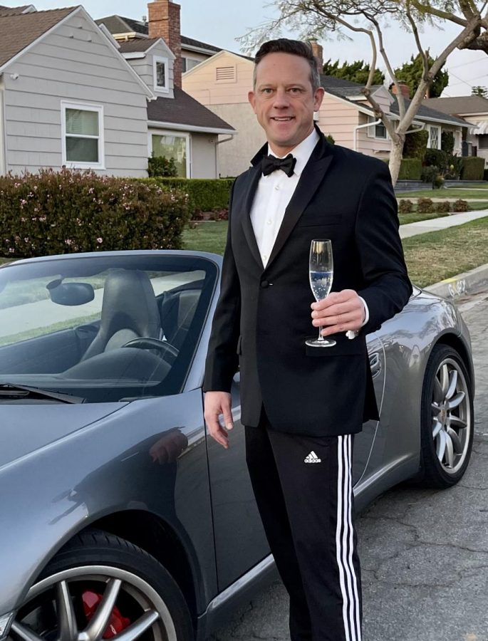 In this photo you can see Duncan White, assistant director of Borat: Subsequent Movie Film, posing next to a Porsche before watching the Oscars over Zoom. A true Covid outfit: suit on top, sweatpants on bottom. 