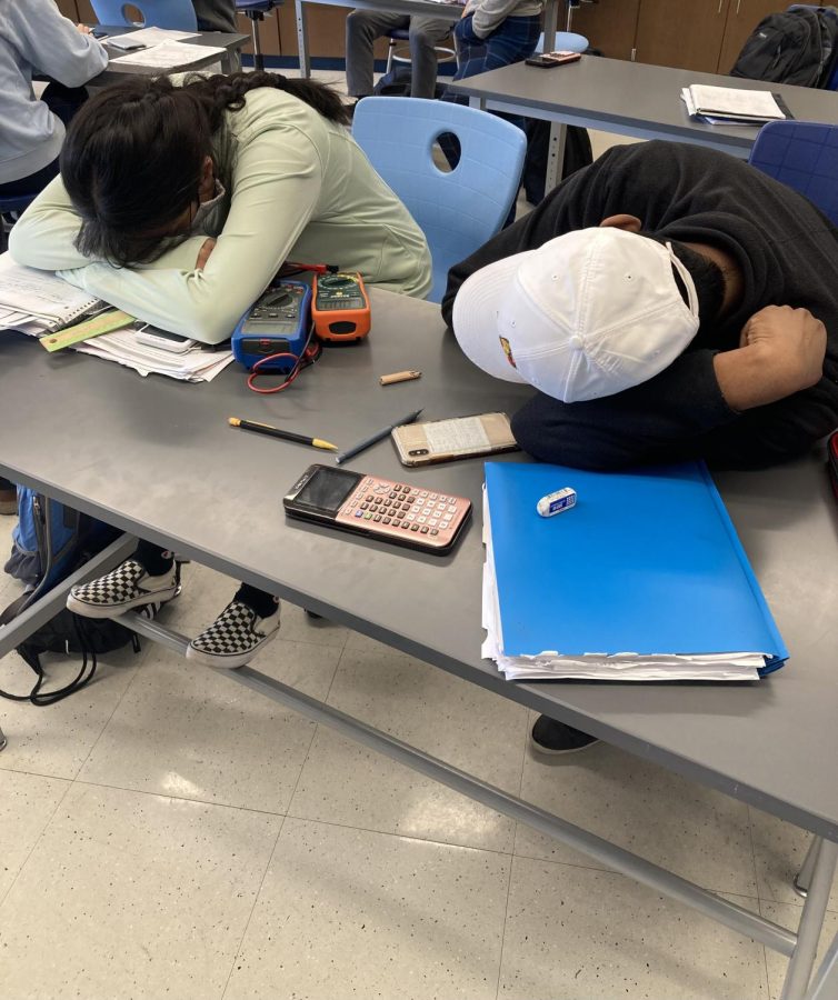 AP Physics C students rest their heads on their desk after they finished their lab
