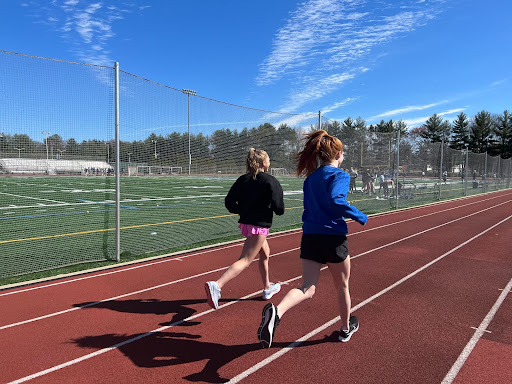 Ellie Goldstein and Bridget McGann warm up before they start their track workout.