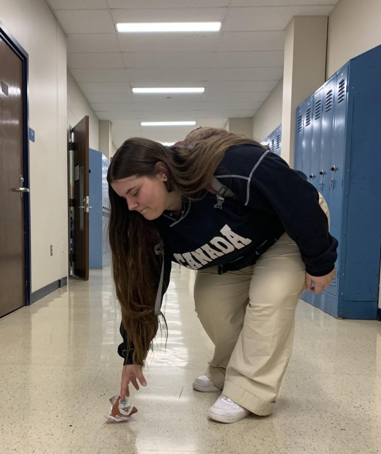 Jenna Beaudoin picking up trash in one of Hall High Schools hallways on October 21st, 2022.