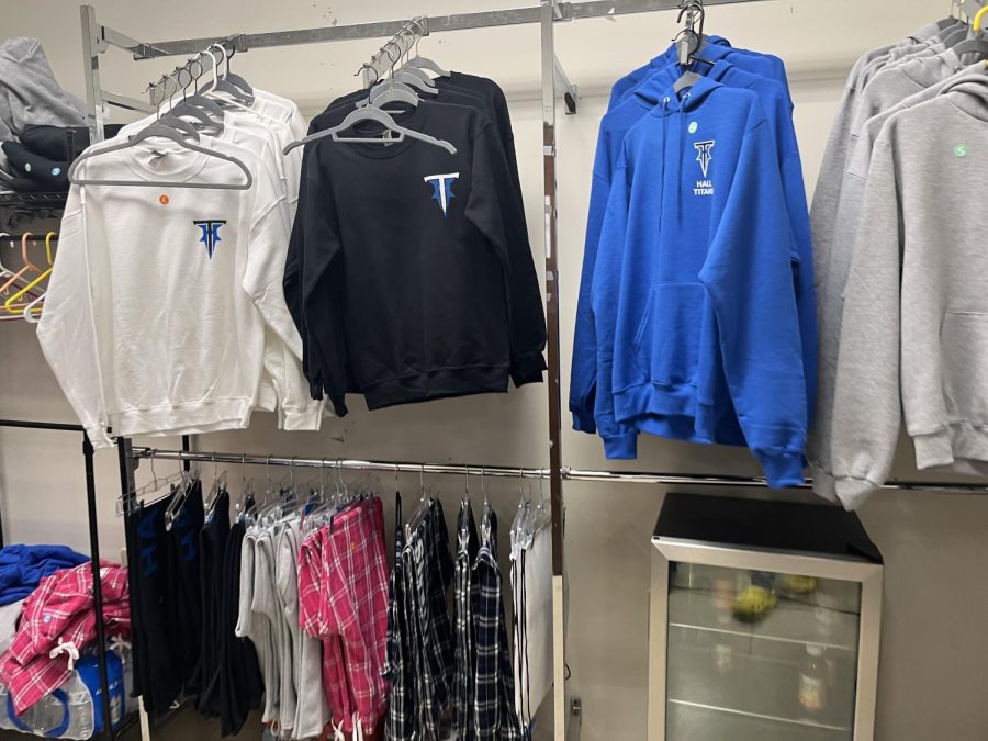 Crewnecks with new Titians logo lined up along school store wall in February 2023