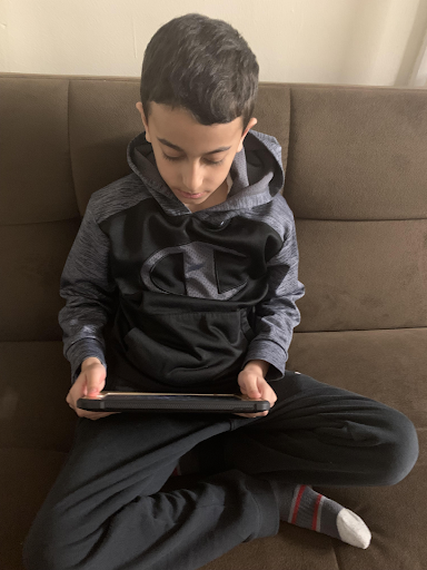 A young boy playing on his IPad, March 10, 2023