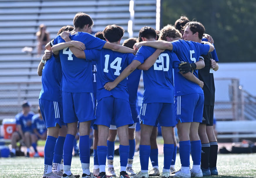 The starting team for Hall has a huddle right before the game at half field. 