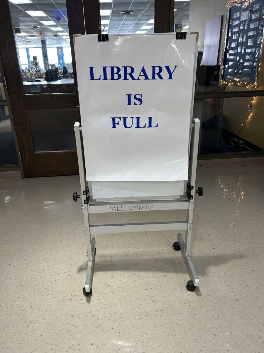 The library is filled with students. Posted sign of no longer allowing students in. 4/24/25