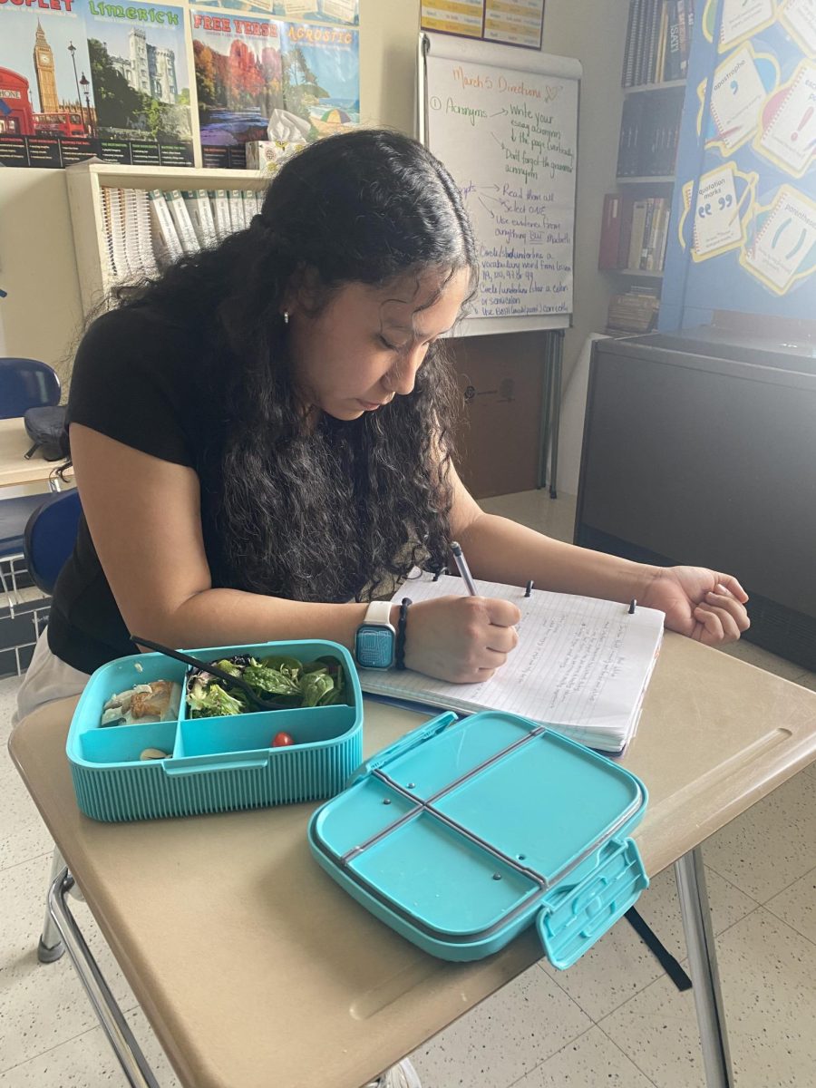 Flavia Choy, a senior at Hall HS, eating lunch in class.