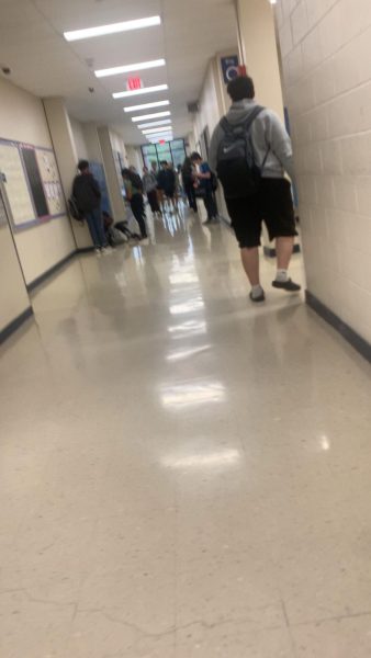 A hallway with a ton of people going to their first period after the first bell rings.