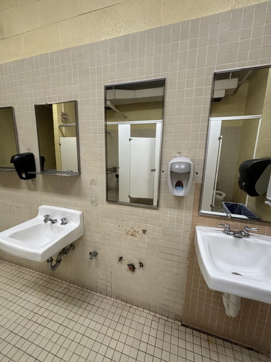 Girls locker room bathroom with sink missing from below mirror 
