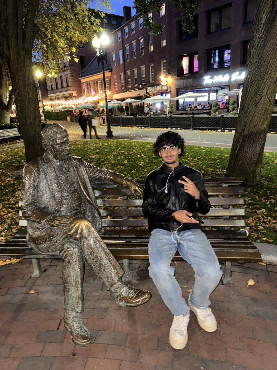 Shah Sheikh in Boston, Massachusetts posing with a statue on a bench in front of Town Hall.  