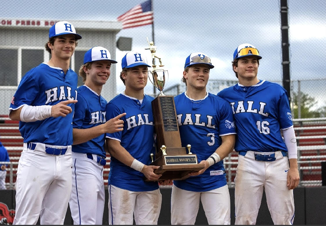 2 senior captains from Hall High School hold the mayor's cup trophy while surrounded by 3 junior teammates, ending one of the best regular seasons in program history, leaving the team with a 15-5 record heading into the postseason.
