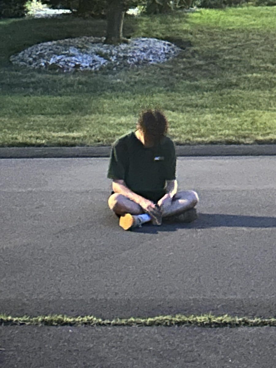 A teen scrolls through his phone on a summer afternoon in West Hartford.